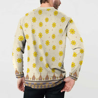 Back of long-sleeve dashiki sweatshirt, off-white with yellow flowers and blue-brown hem pattern