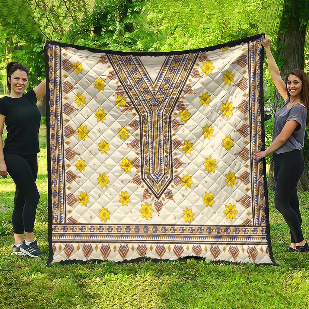 Quilt held outdoors with white ground, yellow flower clusters, blue trim, and zigzag edge
