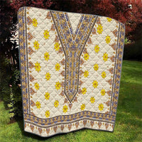 Rolled quilt corner view with white background, yellow flowers, blue borders, and diamond shapes