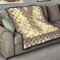 Quilt on sofa with yellow floral pattern, blue border trim, and diamond medallion center