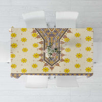 Yellow tablecloth with central blue-and-brown motif and scattered yellow flower designs
