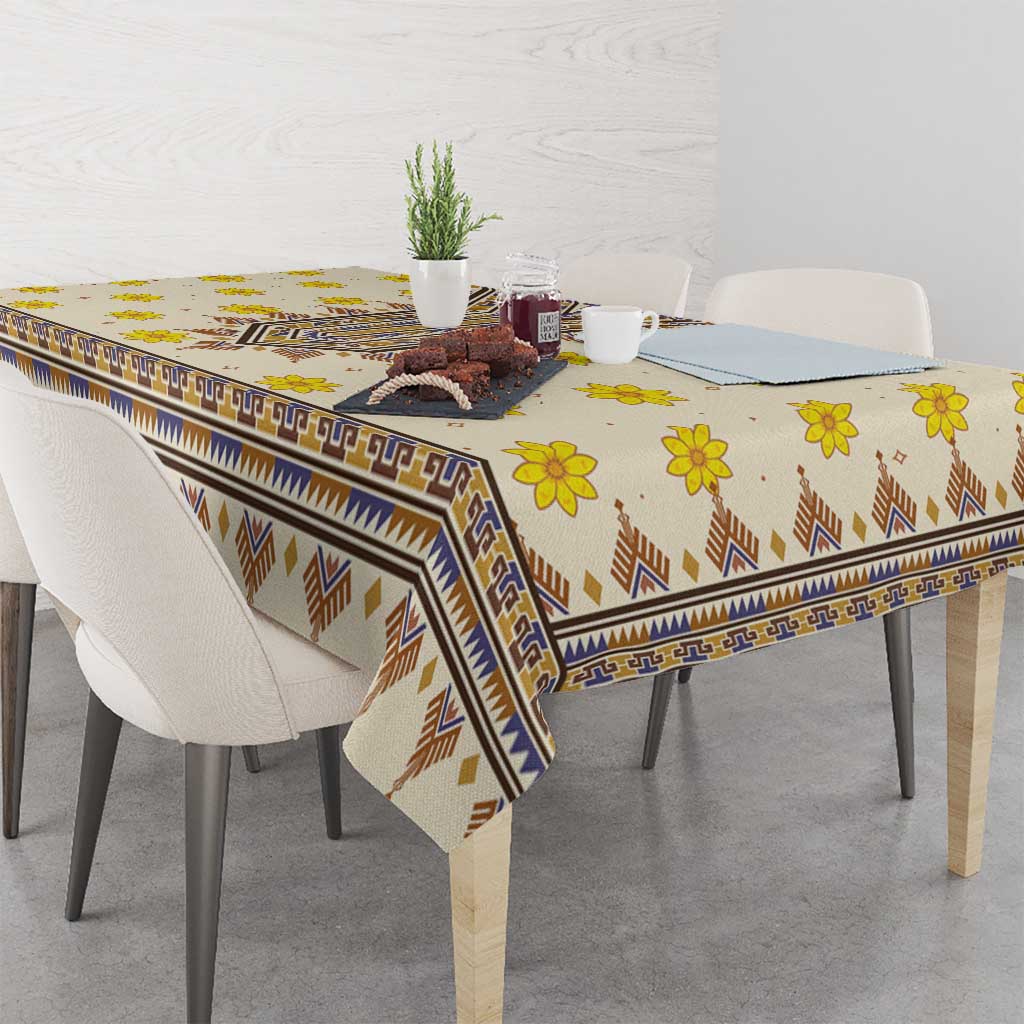 Yellow patterned tablecloth with blue stripe border and brown chevron accents on table