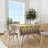 Yellow tablecloth with blue geometric border and brown zigzag pattern over dining table
