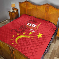 Red quilt on bed with China 2024 design, golden dragon curve and yellow stars