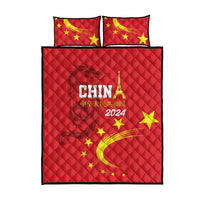 Red quilt bed set with China 2024 print, yellow stars, and two pillowcases on display.