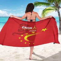 Red China 2024 sarong with dragon emblem, yellow stars, and flowing flame design