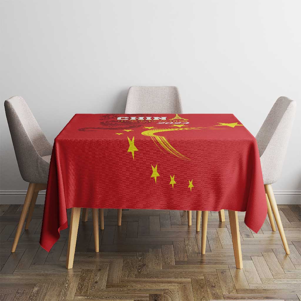 Red tablecloth with gold stars and dragon artwork on a dining table setup
