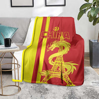 China blanket on couch with red-yellow stripes and gold dragon with Eiffel Tower