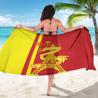 Custom sarong draped on beach, red and yellow panels with dragon and Eiffel Tower graphic