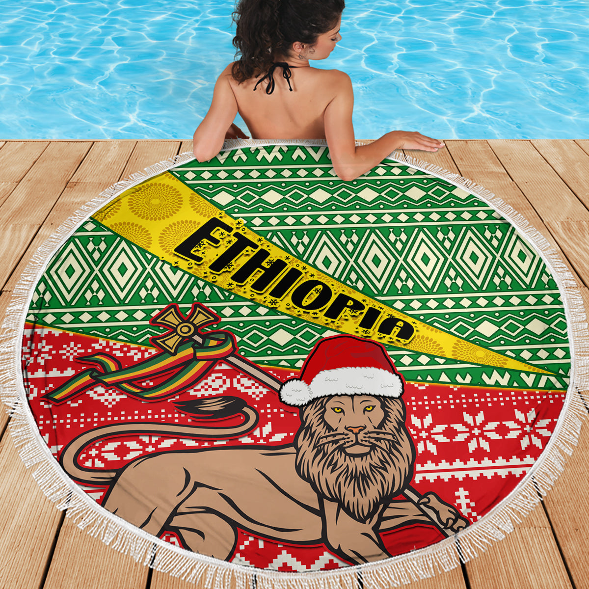 Round beach blanket with green geometric band, red knit-style lion scene, white fringed edge