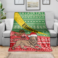 Ethiopian Christmas blanket draped on couch, showing green lattice stripes and red lion illustration