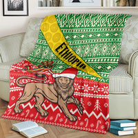 Ethiopian Christmas throw blanket with green patterned top, yellow diagonal band, and red animal