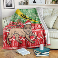 Ethiopian Christmas blanket with red base, white snowflake motifs, and camel-and-santa artwork