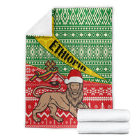 Ethiopian Christmas blanket set with folded throws; green top, yellow band reading ETHIOPIA, red scene