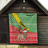 Ethiopian Christmas quilt hanging outdoors: green geometric top, red bottom, lion center