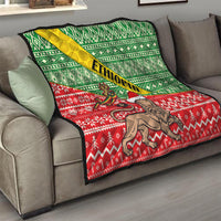 Ethiopian Christmas quilt on couch: green diamond pattern, red snowflake motifs, lion