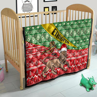 Ethiopian Christmas quilt on toddler bed: green and red festive pattern with lion art