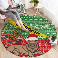 Round area rug with green diamonds, red border, bearded lion wearing Santa hat