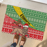 Rubber doormat with green geometric and red knit-style holiday pattern, ETHIOPIA banner stripe