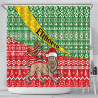 Shower curtain in green, red, and yellow with Ethiopian-style cross, lion, and stripes