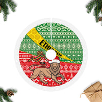 Round Christmas tree skirt with green and red geometric pattern, yellow sash, white fringe