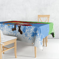 Holiday Christmas tablecloth draped on a table showing Santa camel and blue snow pattern