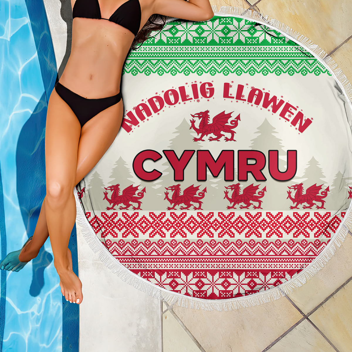 Round beach blanket on poolside: CYMRU text in red with Welsh dragon pattern, fringe