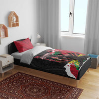 Bedding set on a wooden bed frame: red and black patterned duvet with two pillows