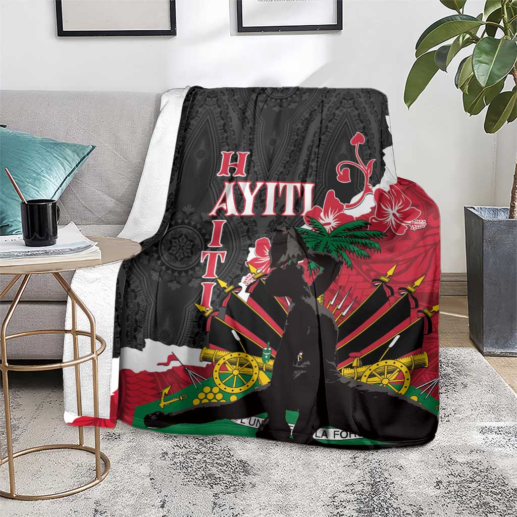 Black blanket on sofa with hibiscus and compass-style motifs in red, green, and yellow