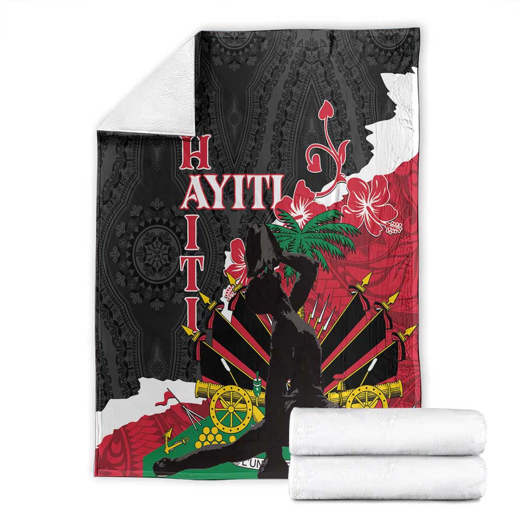 Black blanket folded with hibiscus and compass-style geometric print in red and green