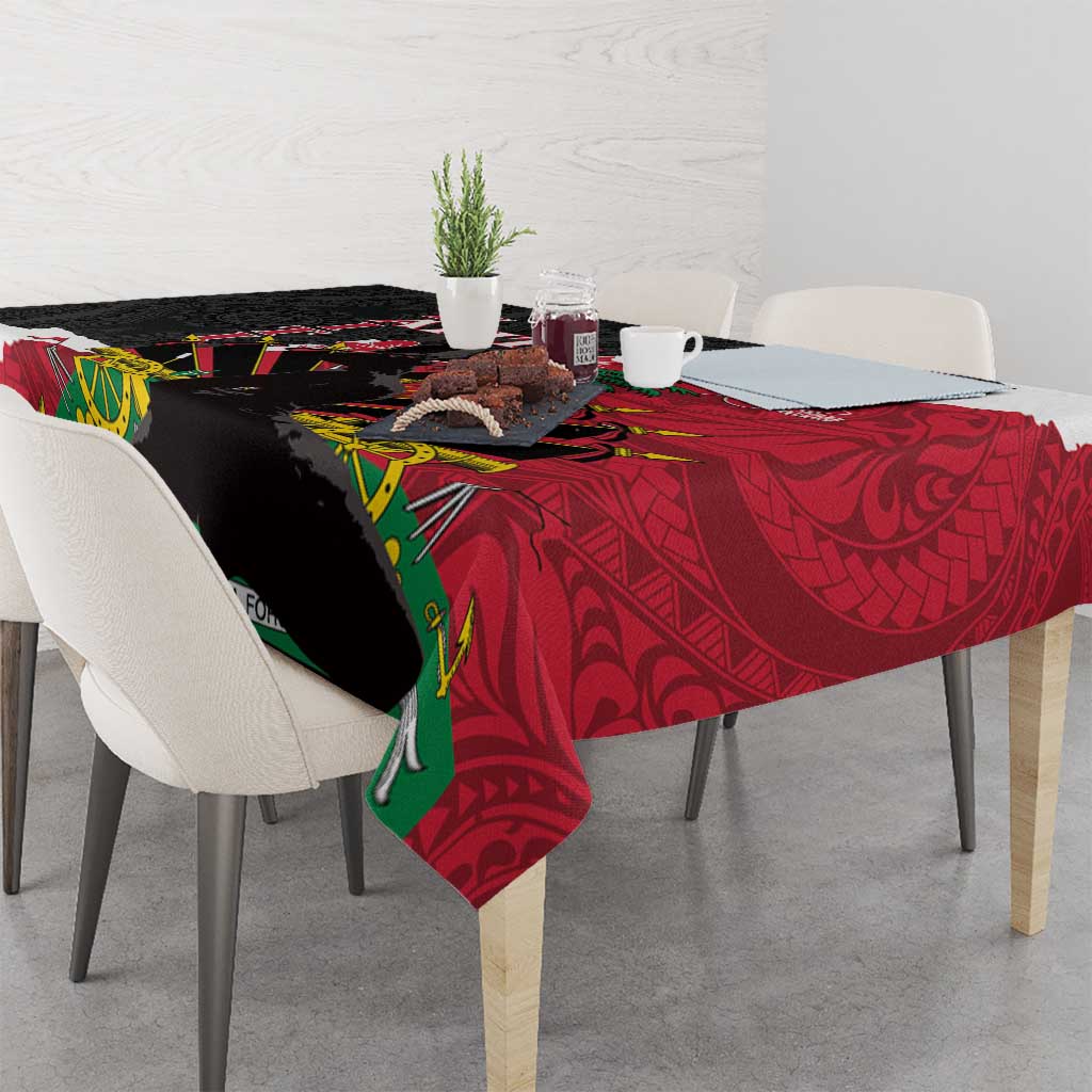 Tablecloth draped over table edge, black and red polynesian design with green accents