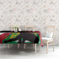 Black and red polynesian tablecloth covering dining table with green and yellow details