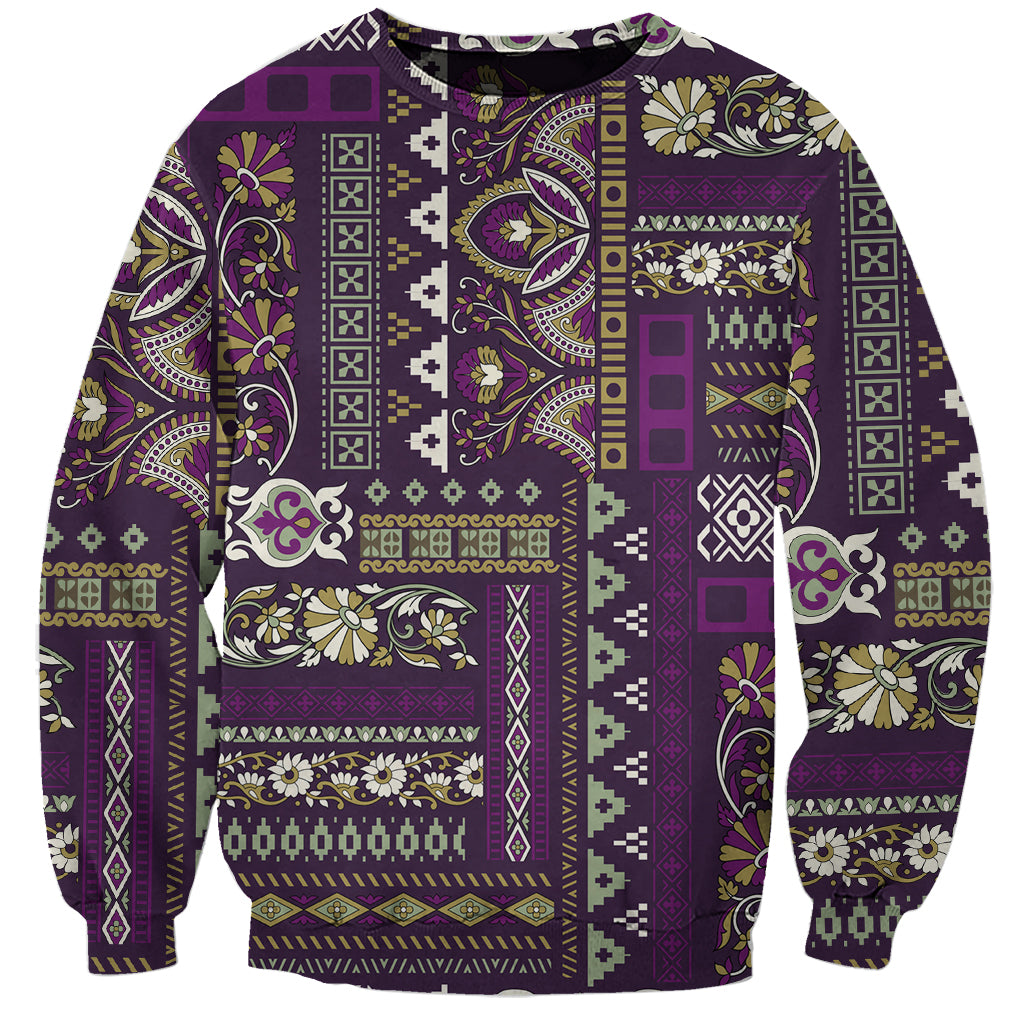 Purple crewneck sweatshirt with colorful patchwork pattern and long sleeves, ribbed cuffs