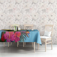 Sky blue tropical tablecloth with pink and purple flowers and leaf motifs on table