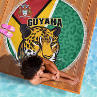 Round green beach blanket featuring Guyana text, jaguar illustration, and white fringe