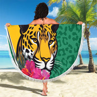 Round green beach blanket with jaguar face and tropical flowers, held outdoors, white fringe