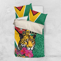 Green bedding set laid flat: jaguar face, flowers, and Guyana logo on duvet & pillowcases