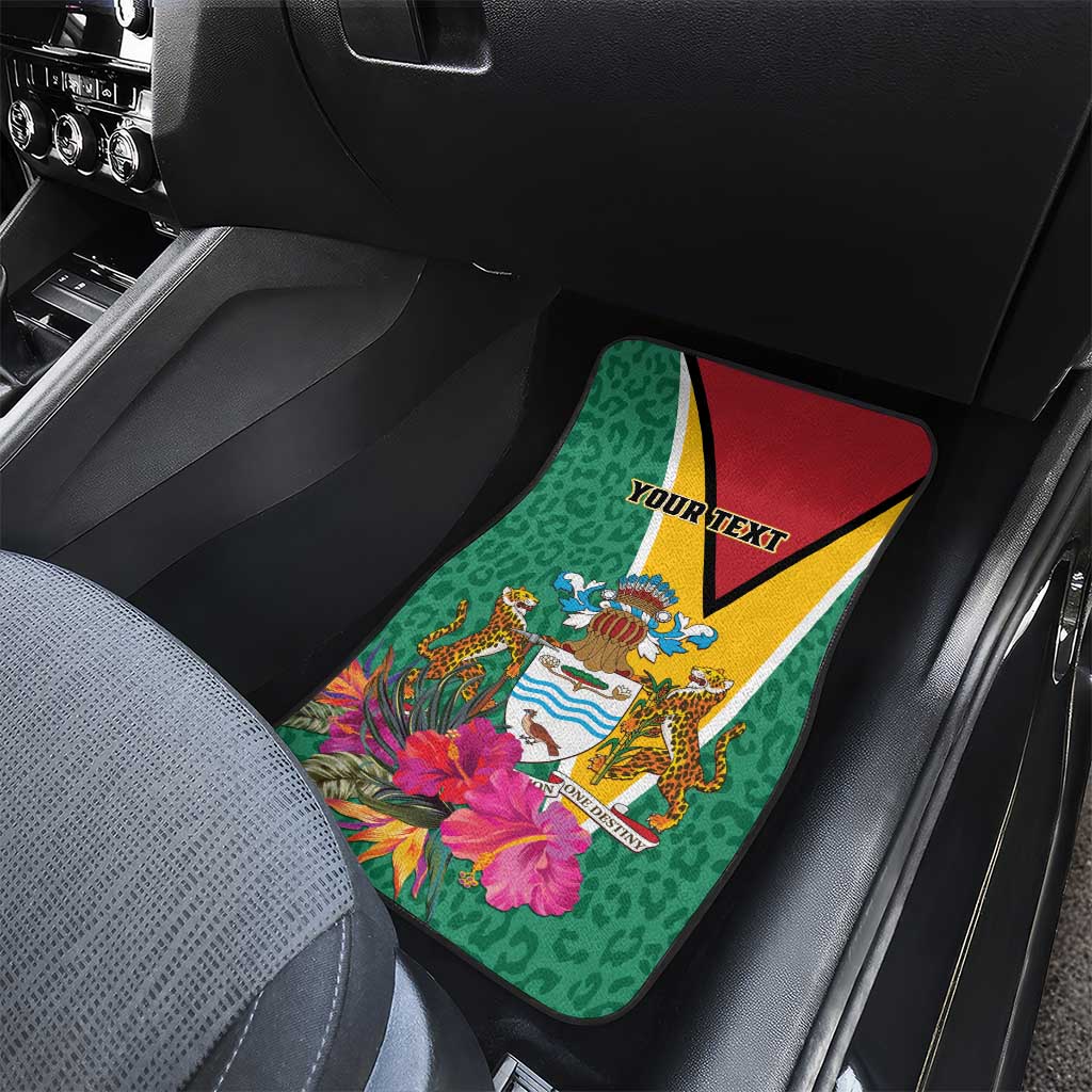 Green car floor mat with Guyana crest and tropical flowers, red/yellow triangle border