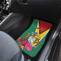 Green car floor mat with Guyana crest and tropical flowers, red/yellow triangle border