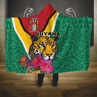 Green hooded blanket with Guyana jaguar graphic and tropical flowers, red hood with stripes