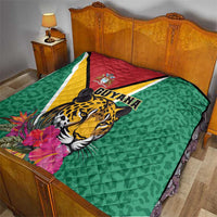 Green Guyana quilt on bed with jaguar design, tropical flowers, and diagonal flag stripe