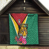 Green Guyana quilt hanging under roof with jaguar artwork and tropical flowers