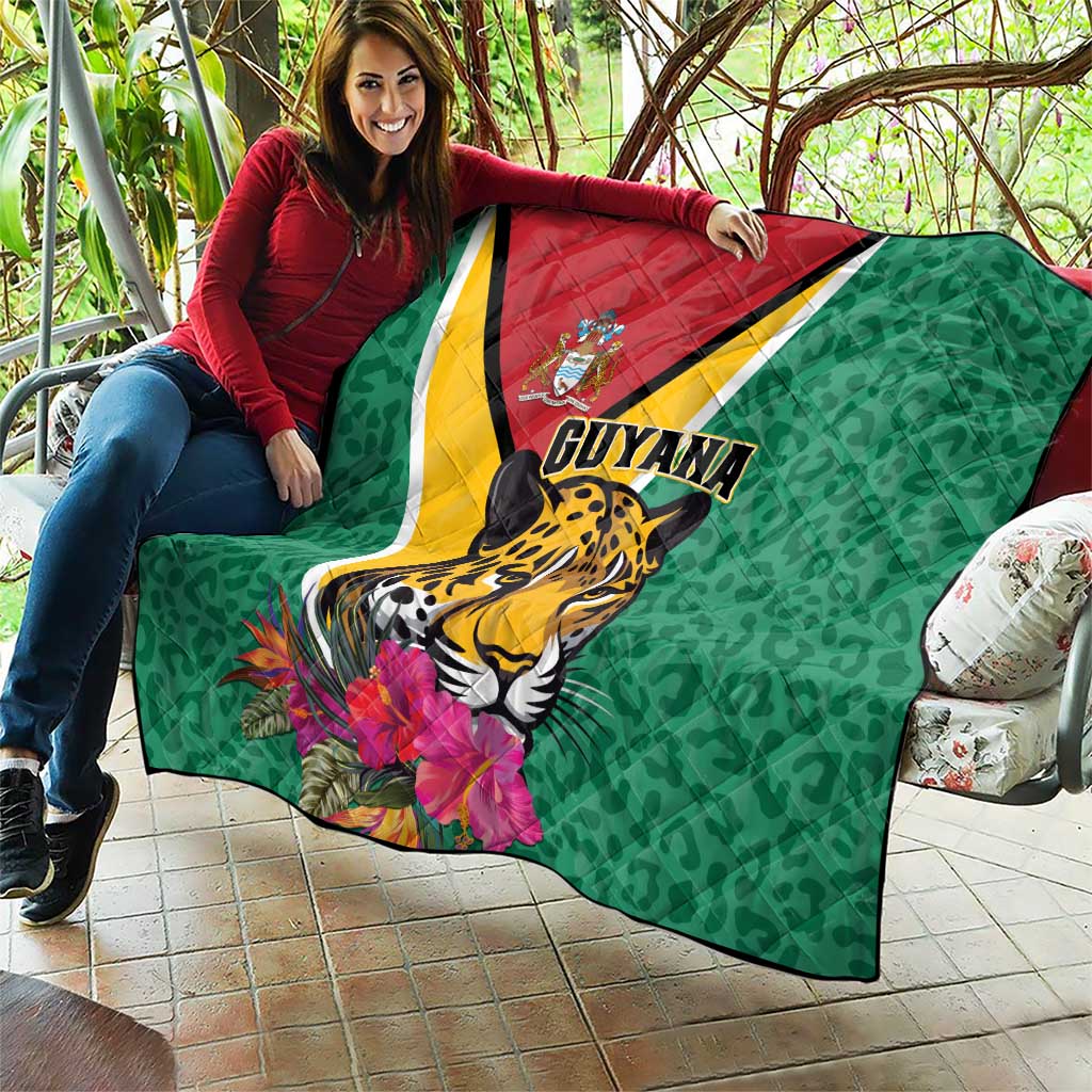 Green Guyana quilt held outdoors showing jaguar, tropical flowers, and diagonal stripe