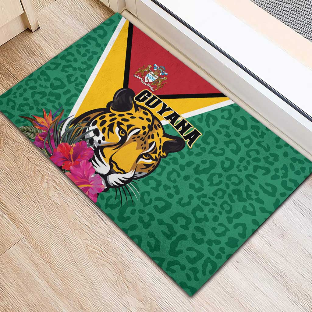 Green rubber doormat corner view with jaguar face, Guyana lettering, and pink flowers