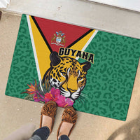 Green rubber doormat with jaguar face, Guyana text, and pink tropical flowers
