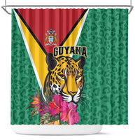 Green shower curtain with Guyana flag triangle, jaguar face, and tropical flowers