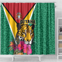 Green shower curtain with jaguar head illustration, Guyana banner, and large tropical blooms