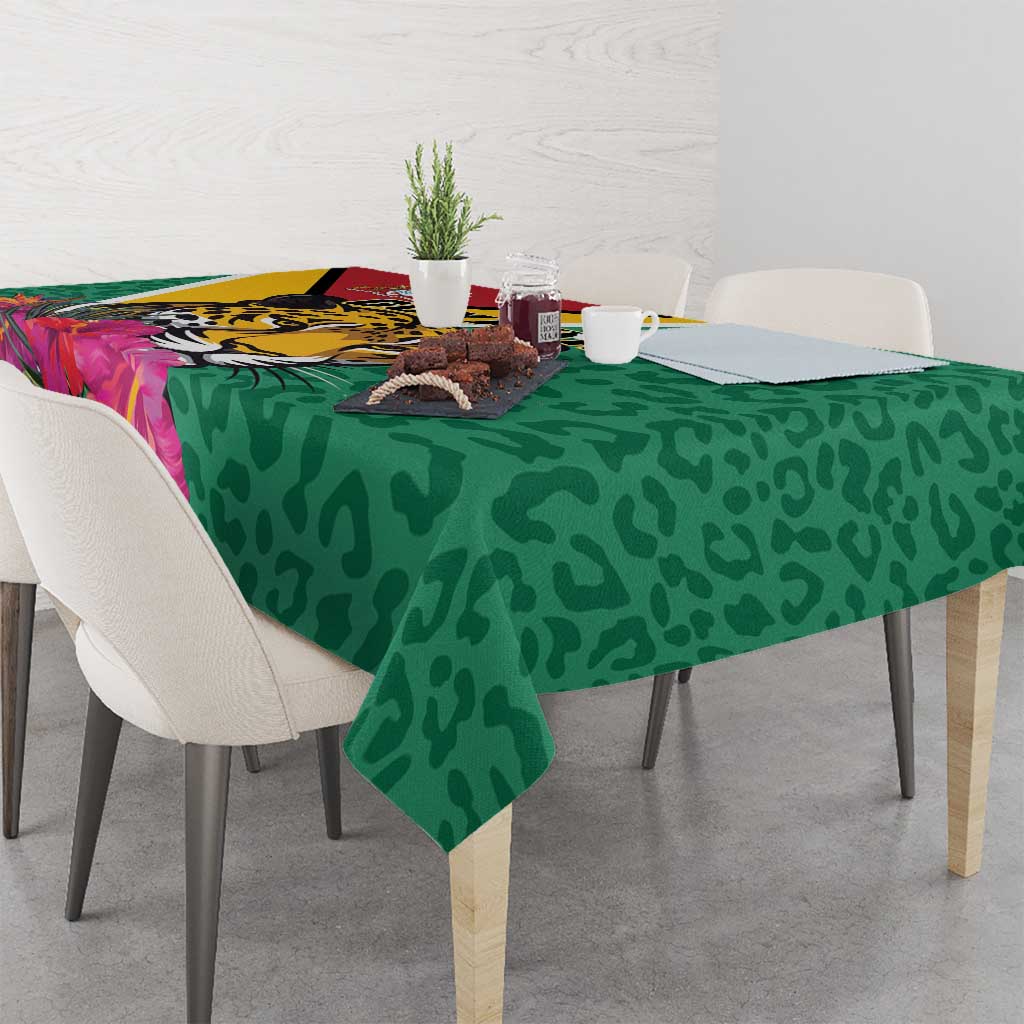 Green tablecloth with jaguar artwork, tropical flowers, and dark spot pattern