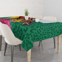 Green tablecloth with jaguar artwork, tropical flowers, and dark spot pattern