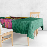 Green tablecloth draped on table edge, jaguar and tropical flower print